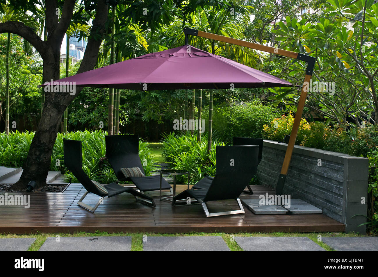 Gartenmöbel mit Sonnenschirm im Garten Stockfoto