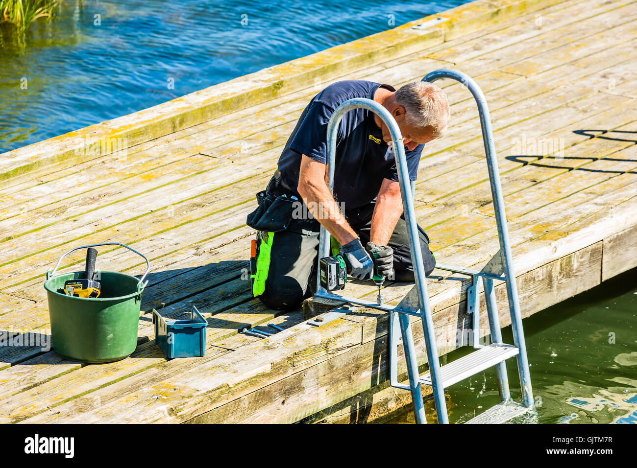Kalmar, Schweden - 10. August 2016: Arbeitskraft Montage Metall Badeleiter auf eine öffentliche Anlegestelle. Stockfoto
