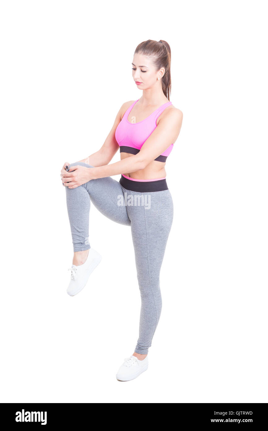 Frau trägt Sportbekleidung stretching Beine vor Training isoliert auf weißem Hintergrund Stockfoto
