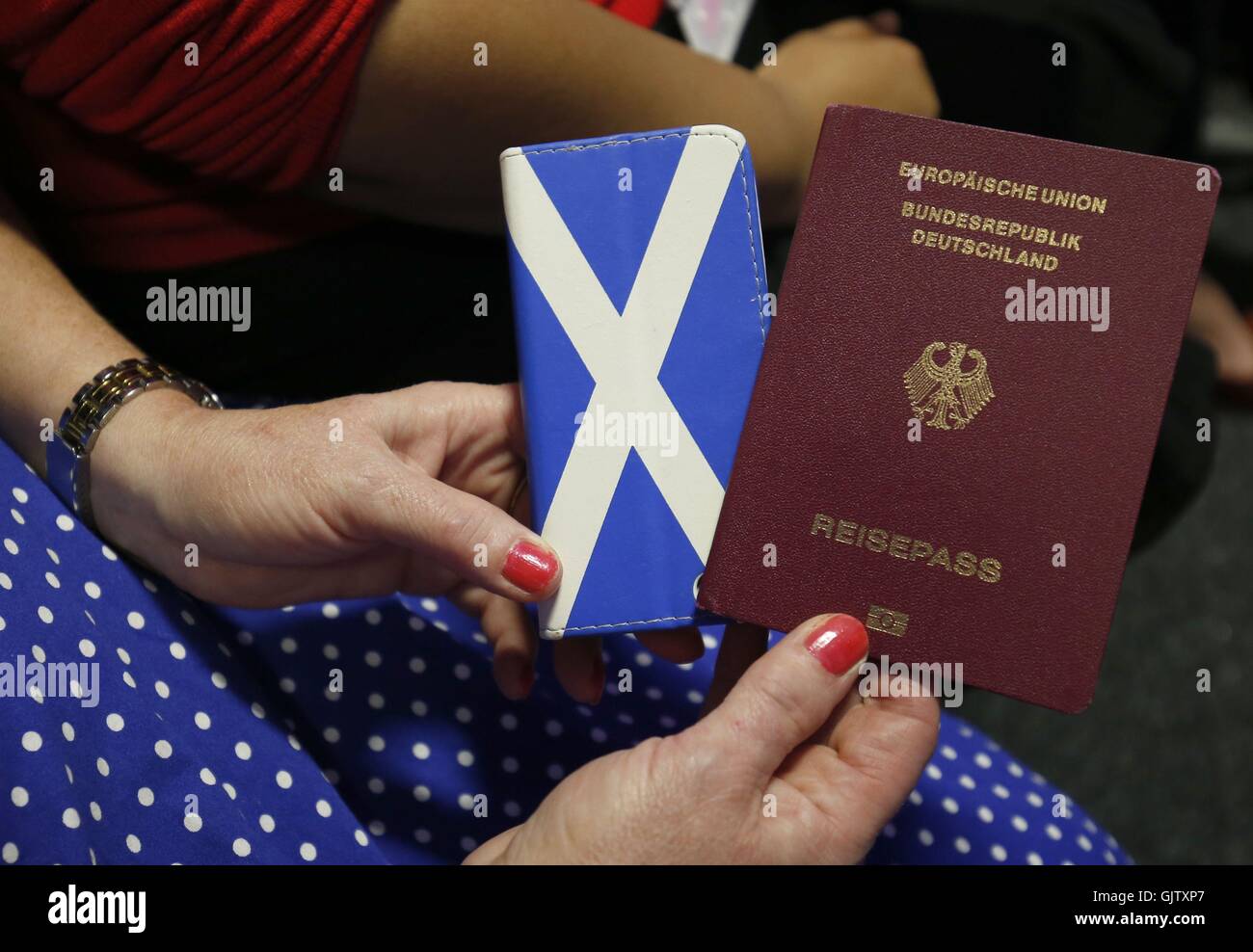 Eine deutsche Frau hält ihren Pass und ein Andreaskreuz Bild während einer öffentlichen Diskussion über das Ergebnis des EU-Referendums und was bedeutet es für EU-Bürger leben in Schottland an der Corn Exchange, Edinburgh. Stockfoto