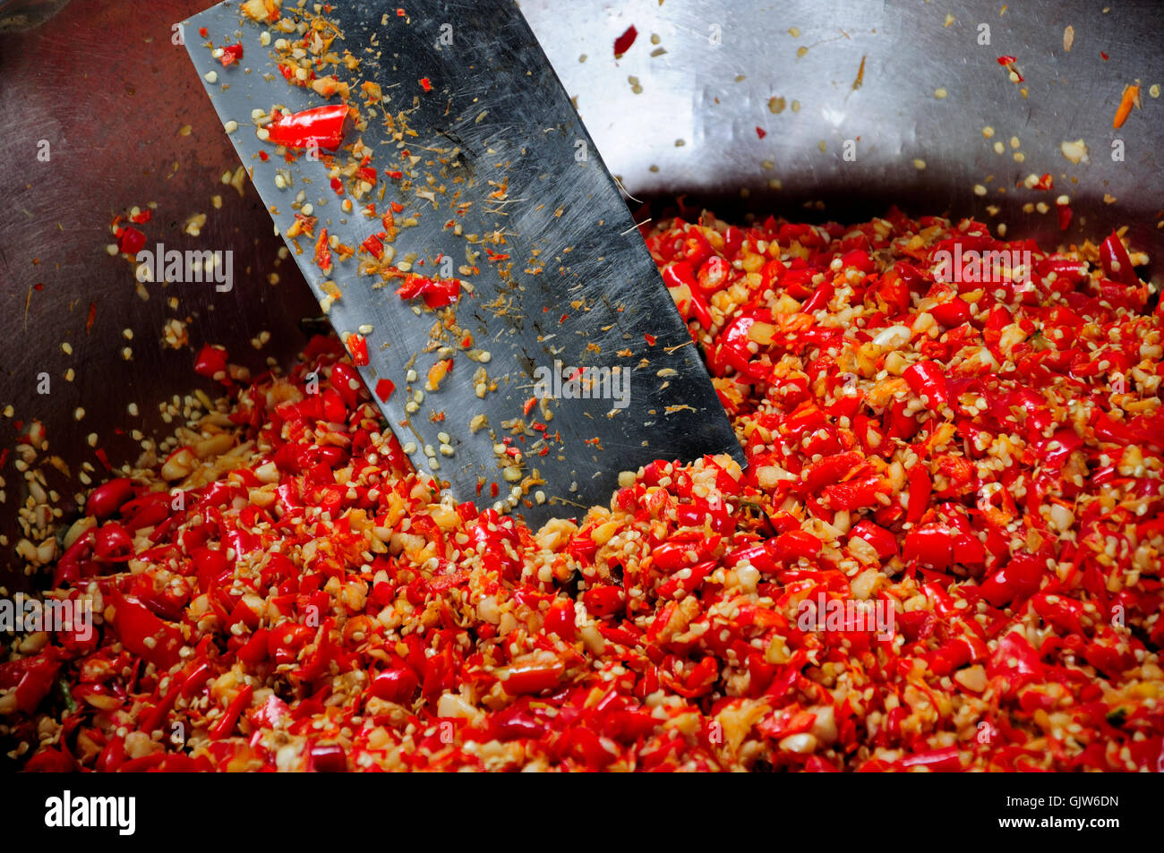 Rote Chilischoten gehackt mit einem Beil in einer Metallschale in Xitang Stadt in der Provinz Zhejiang China. Stockfoto
