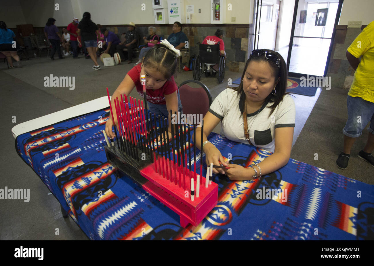 Elgin, Florida, USA. 8. November 2016. eine Frau und ihr Kind ersetzen die scoring-Sticks nach einem Hand-Spiel während der Messe in Elgin, Oklahoma Comanche. Die beiden Teams spielen Handspiel können variieren in der Größe, jedes Team (das Team '' versteckt '' und '' erraten '' Team) müssen einen Kapitän. Das Spiel ist mit zwei Paaren von "Bones", jedes Paar bestehend aus einer Ebene und einem gestreiften Knochen gespielt. Jeder Stamm entscheidet welche Knochen wird erraten, unifarben oder gestreiften Knochen. Oklahoma-Indianer nennen in der Regel für den gestreiften Bone. Die beiden Teams, ein '' versteckt '' und 1 '' raten, '' sitzen einander gegenüber; TW Stockfoto