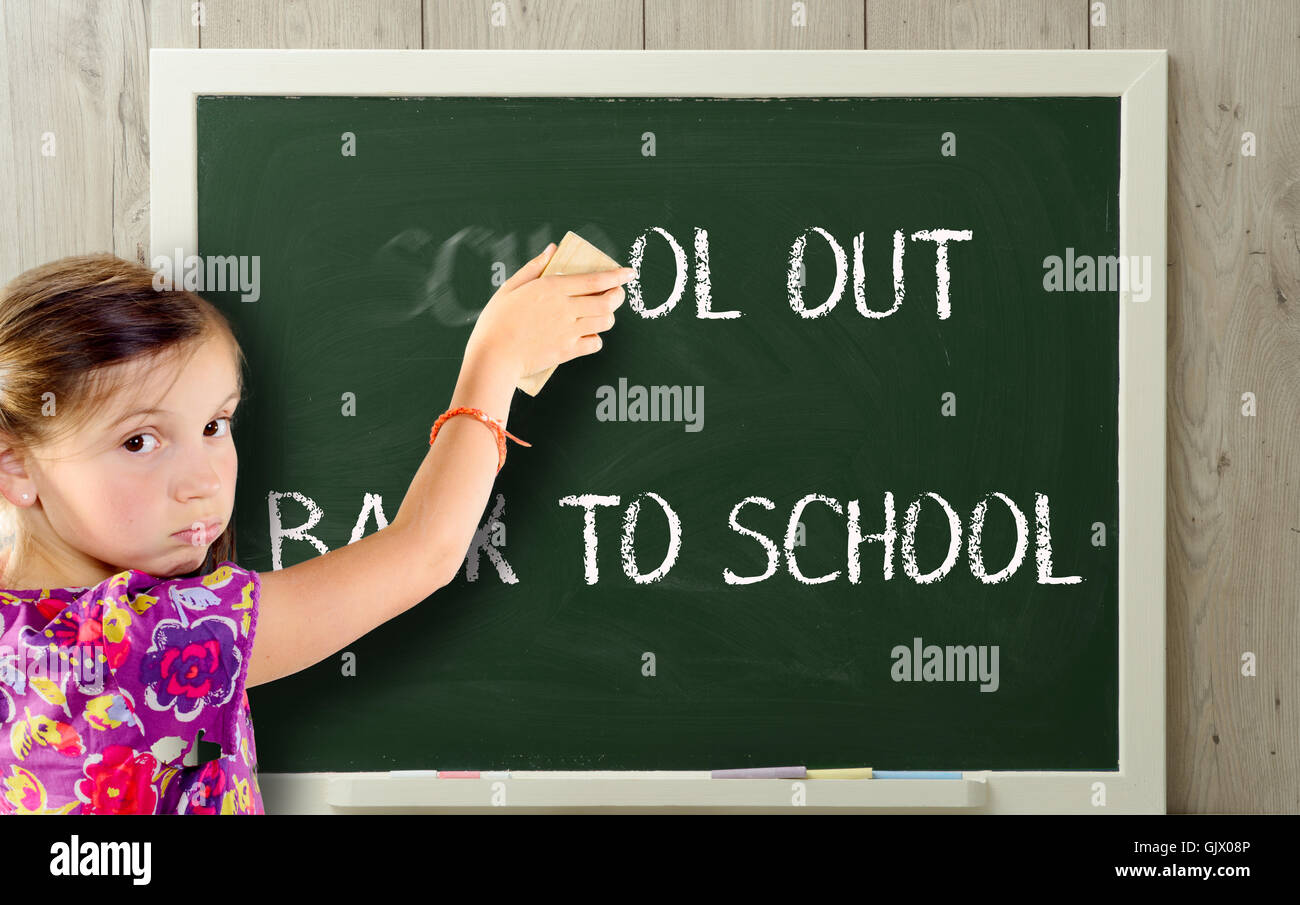 eine Mädchen entrümpelt Schule auf greenblackboard Stockfoto