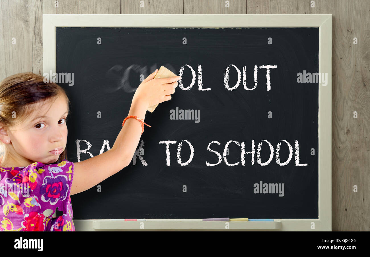 eine Mädchen entrümpelt Schule an Tafel Stockfoto