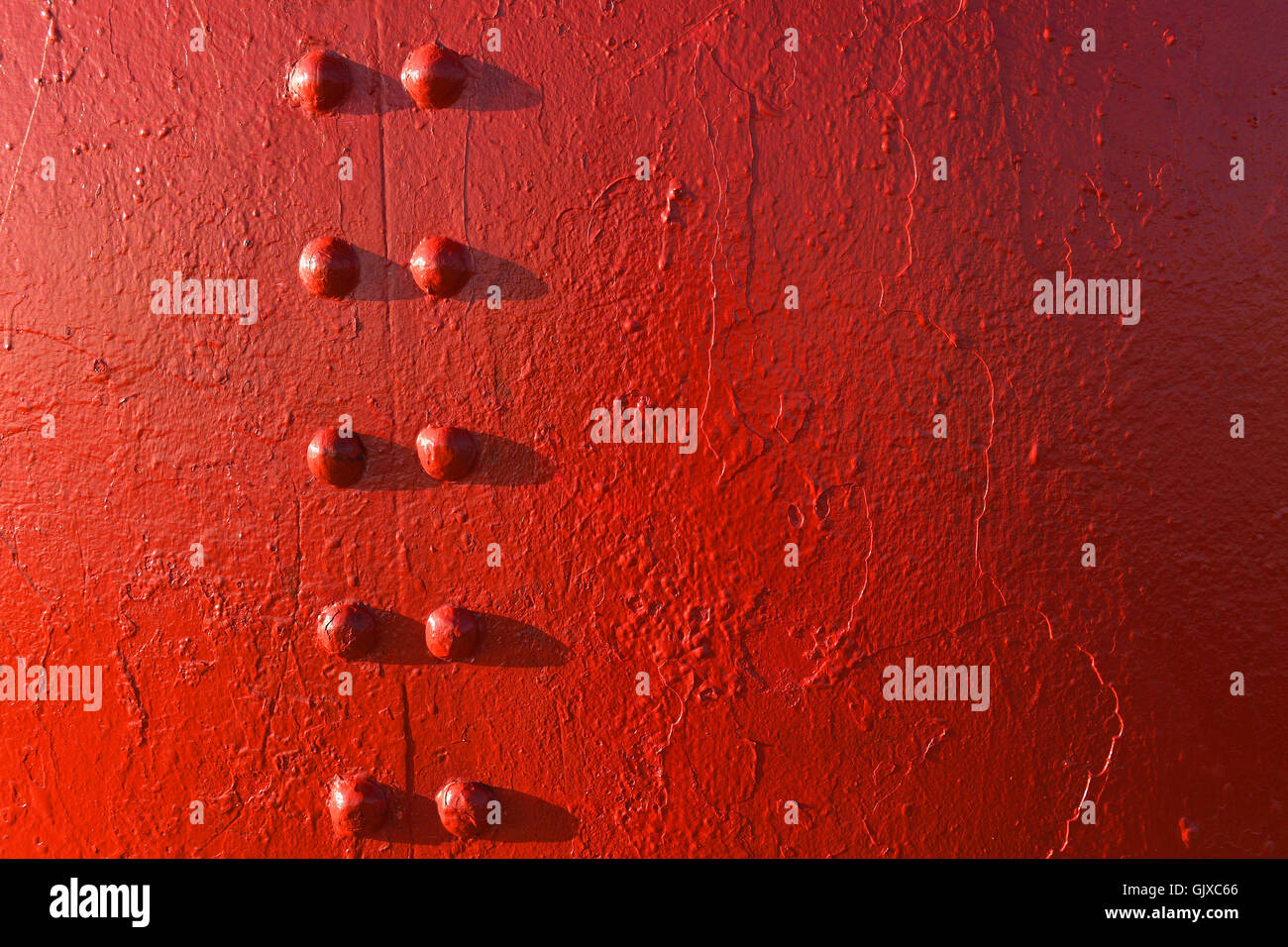 Rot lackierte Oberfläche mit Schrauben mit leichten Gefälle Stockfoto