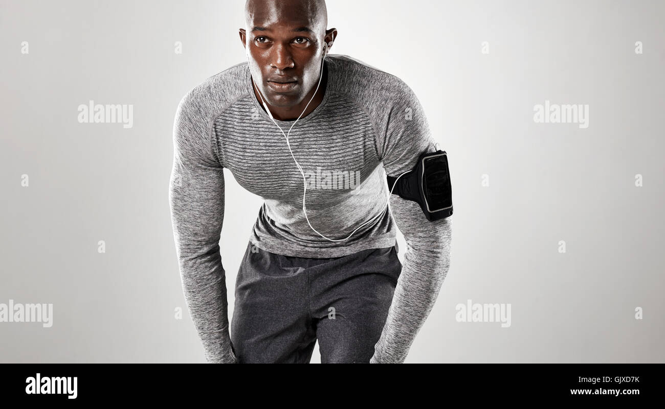 Jungen Mann bereit für den Betrieb auf grauem Hintergrund konzentriert. Muskulösen afrikanischen Männermodel in Sportbekleidung. Stockfoto