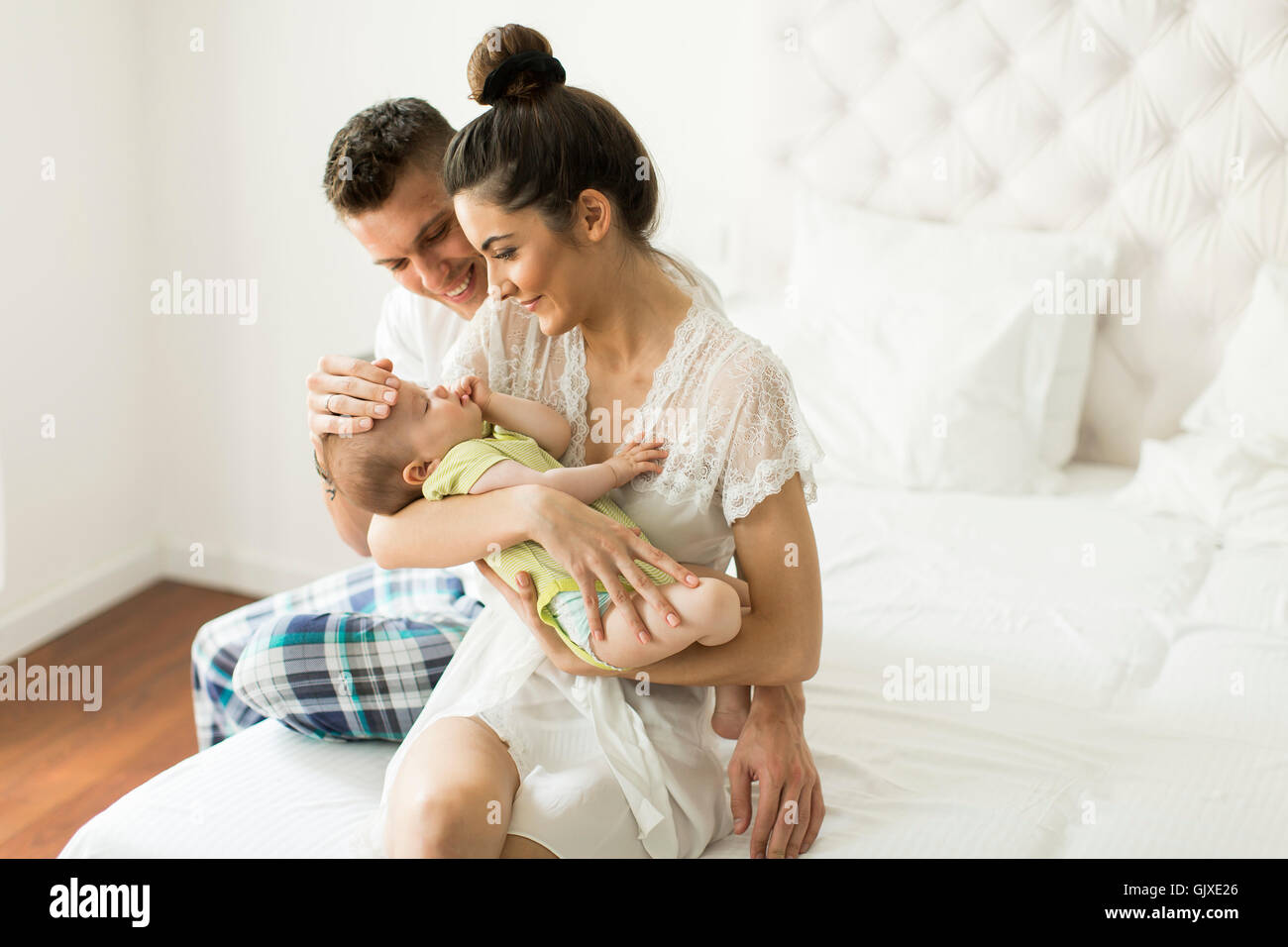 Junges Paar auf dem Bett mit Baby girl Stockfoto