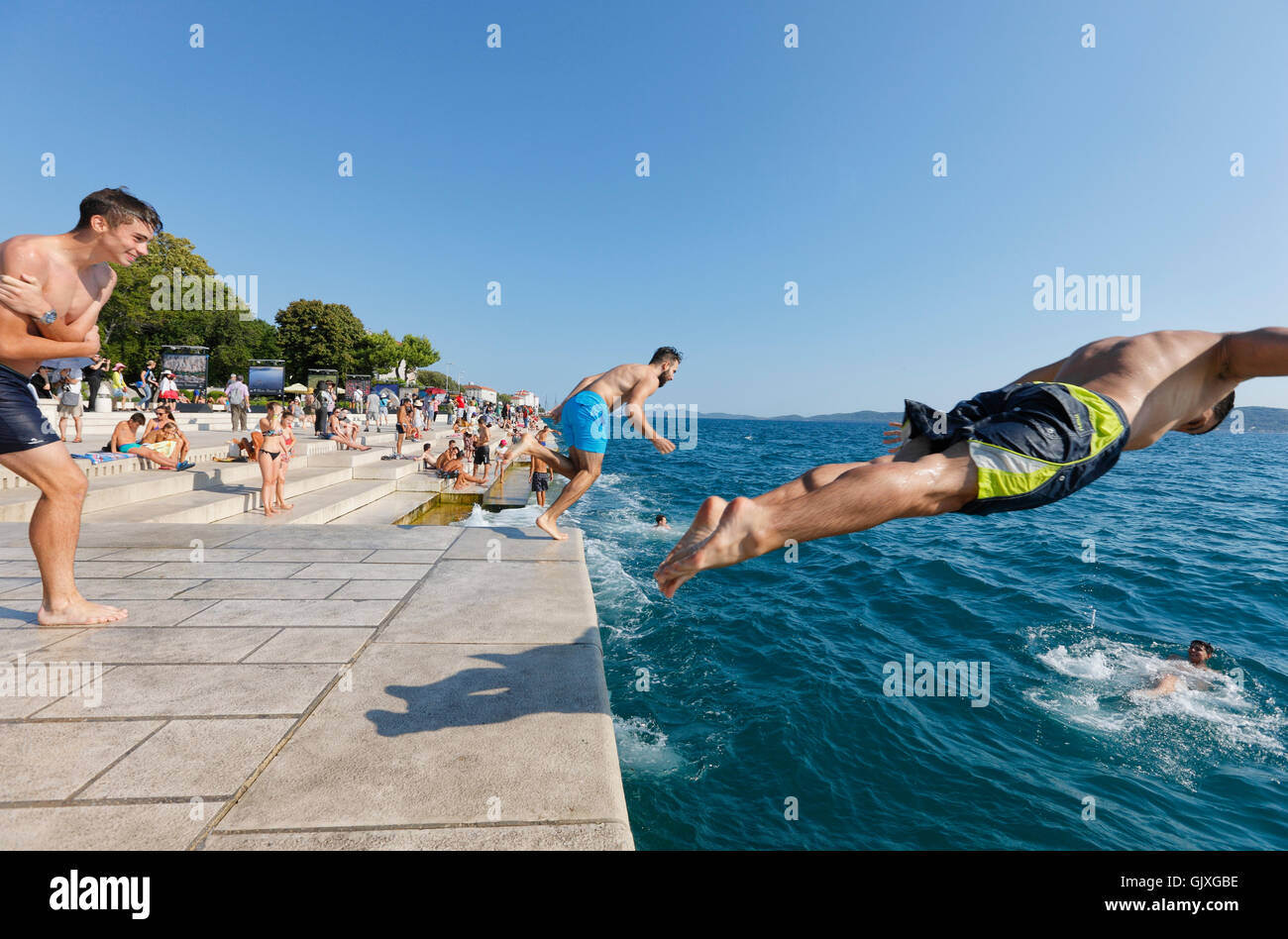 Touristen ins Wasser springen in der Nähe von die Meeresorgel in Zadar Stockfoto