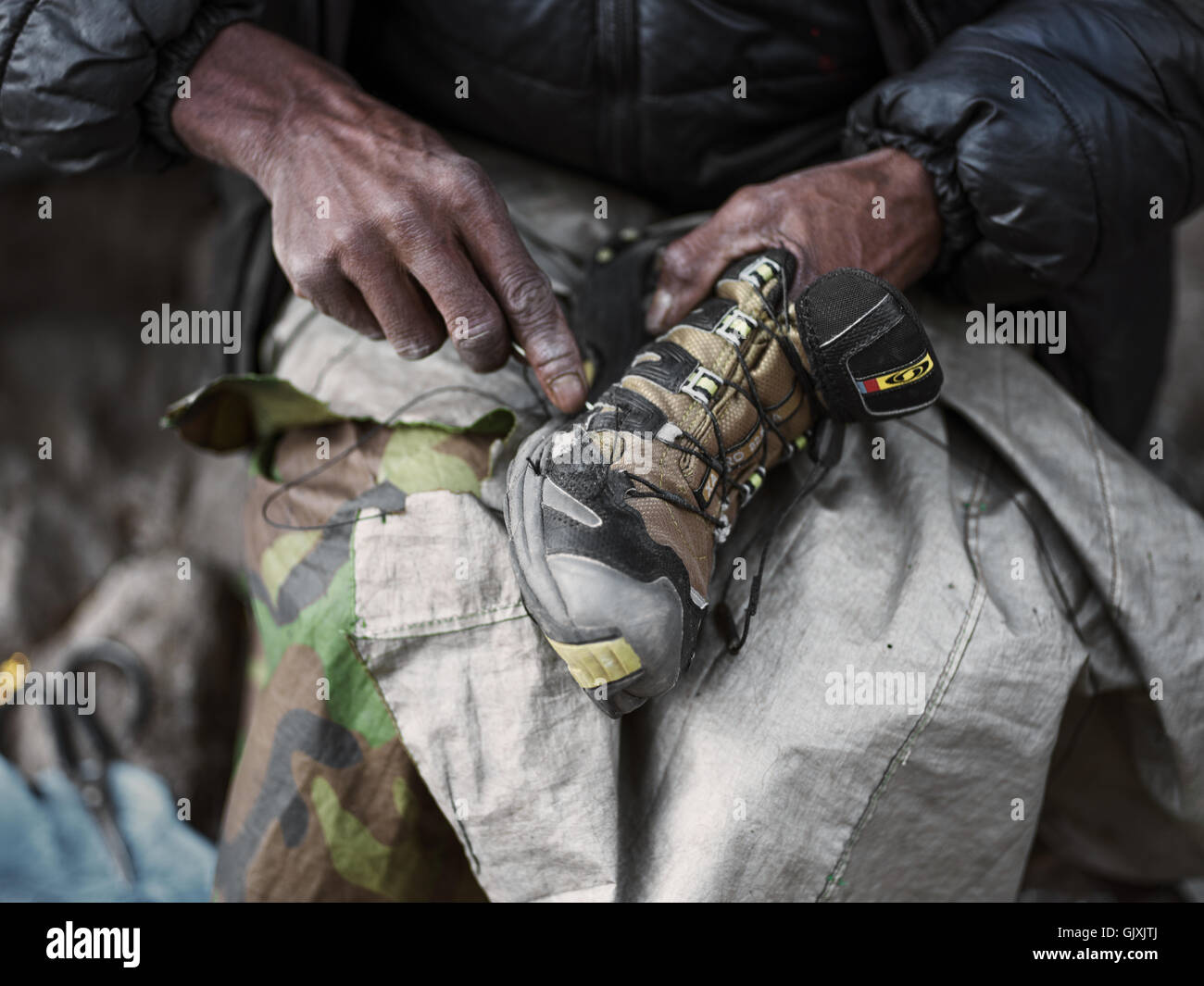 Ein nepalesischer Mann repariert Schuhe in Namche, Nepal Stockfoto