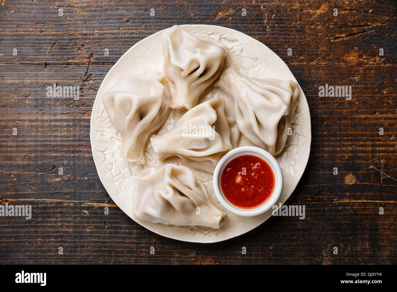 Georgische Knödel Khinkali mit Fleisch und Tomatensauce würzig Satsebeli auf weißen Teller Stockfoto