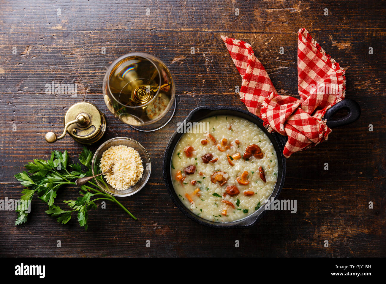 Risotto mit Pfifferlingen in Pfanne auf Holztisch Stockfoto