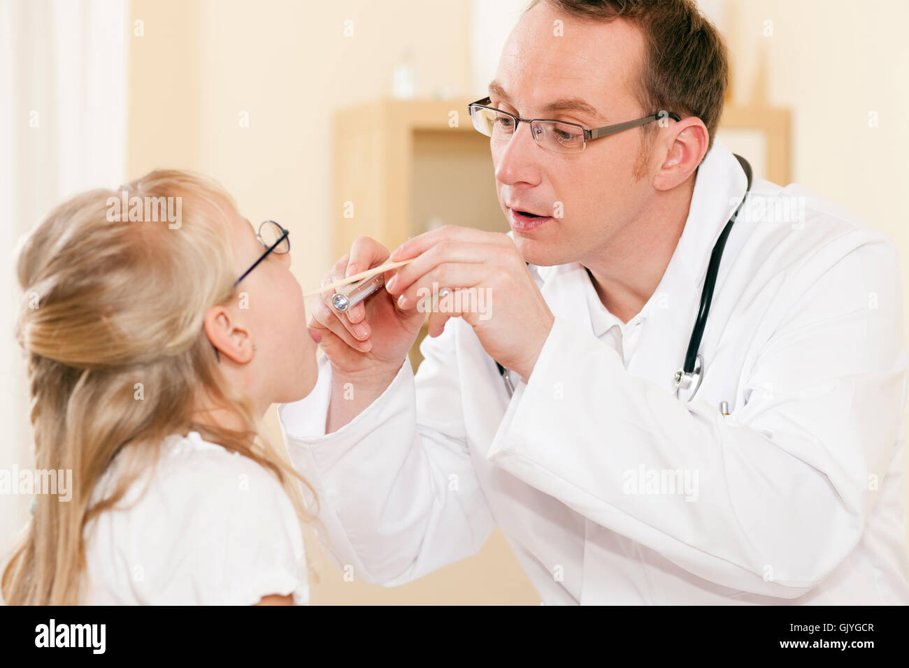 Arzt untersucht seinen Patienten in den Rachen Stockfoto