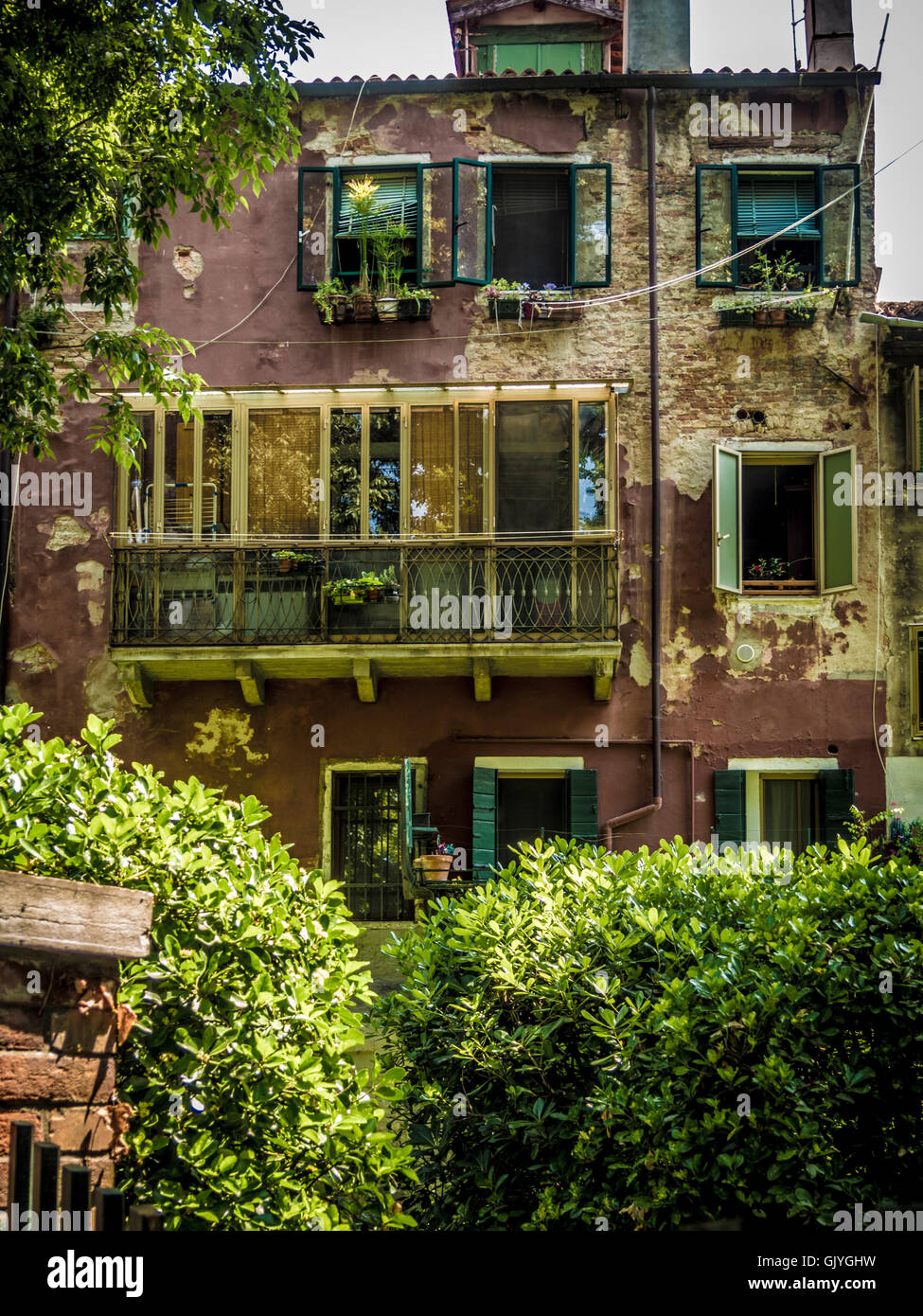 Traditionelle braun gerendert Gebäude mit Jalousien und Rollläden an den Fenstern. Stockfoto