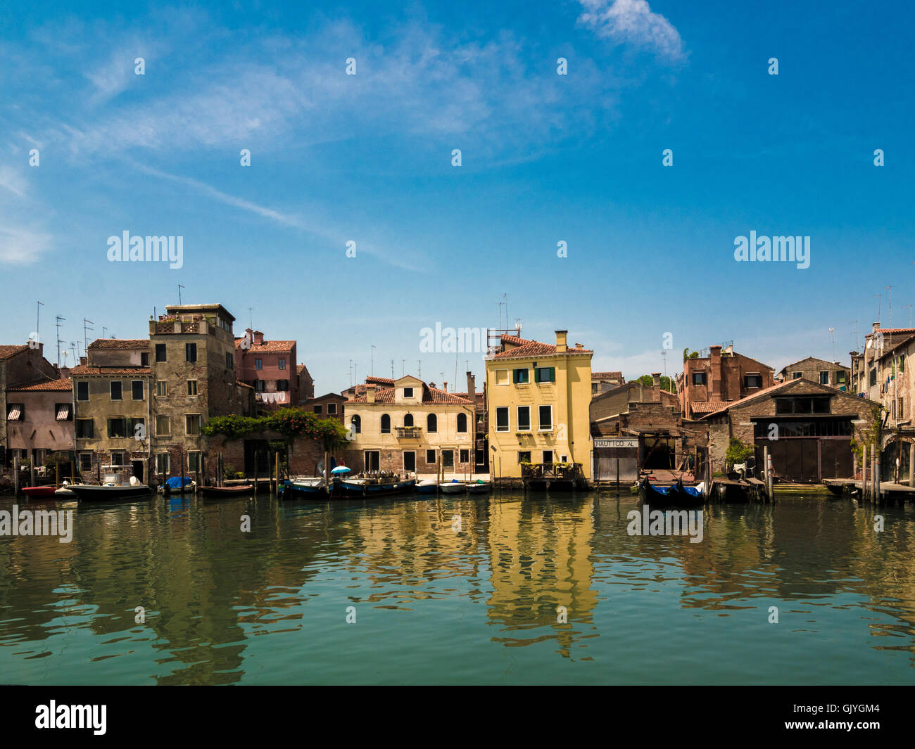 Traditionelle Gebäude mit festgemachten Boote und Gondeln auf dem Canale di San Pietro, Venedig. Italien. Stockfoto