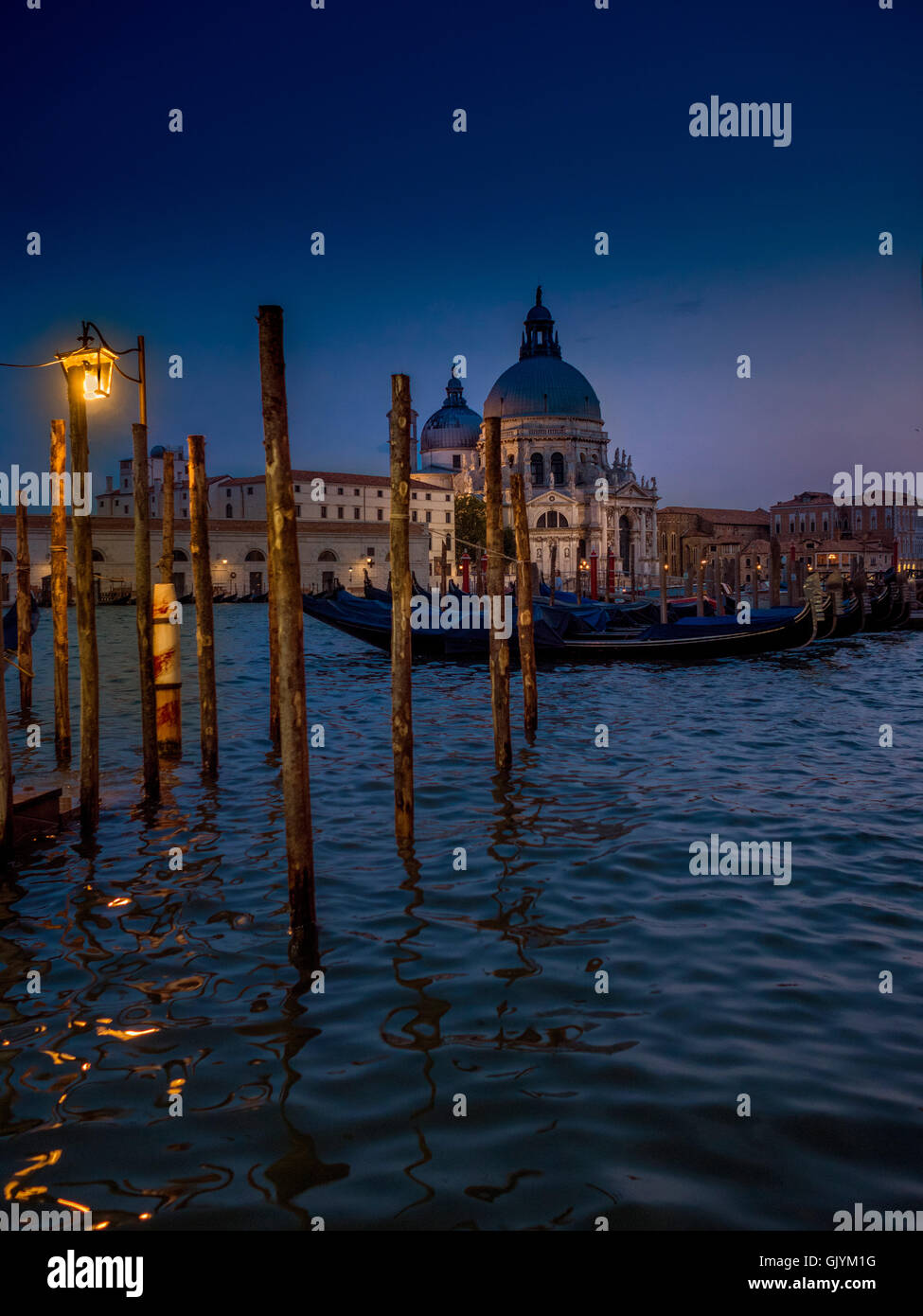 Gondeln vor Anker für die Nacht am Canal Grande mit der Kirche Santa Maria della Salute im Hintergrund. Venedig, Italien., Stockfoto