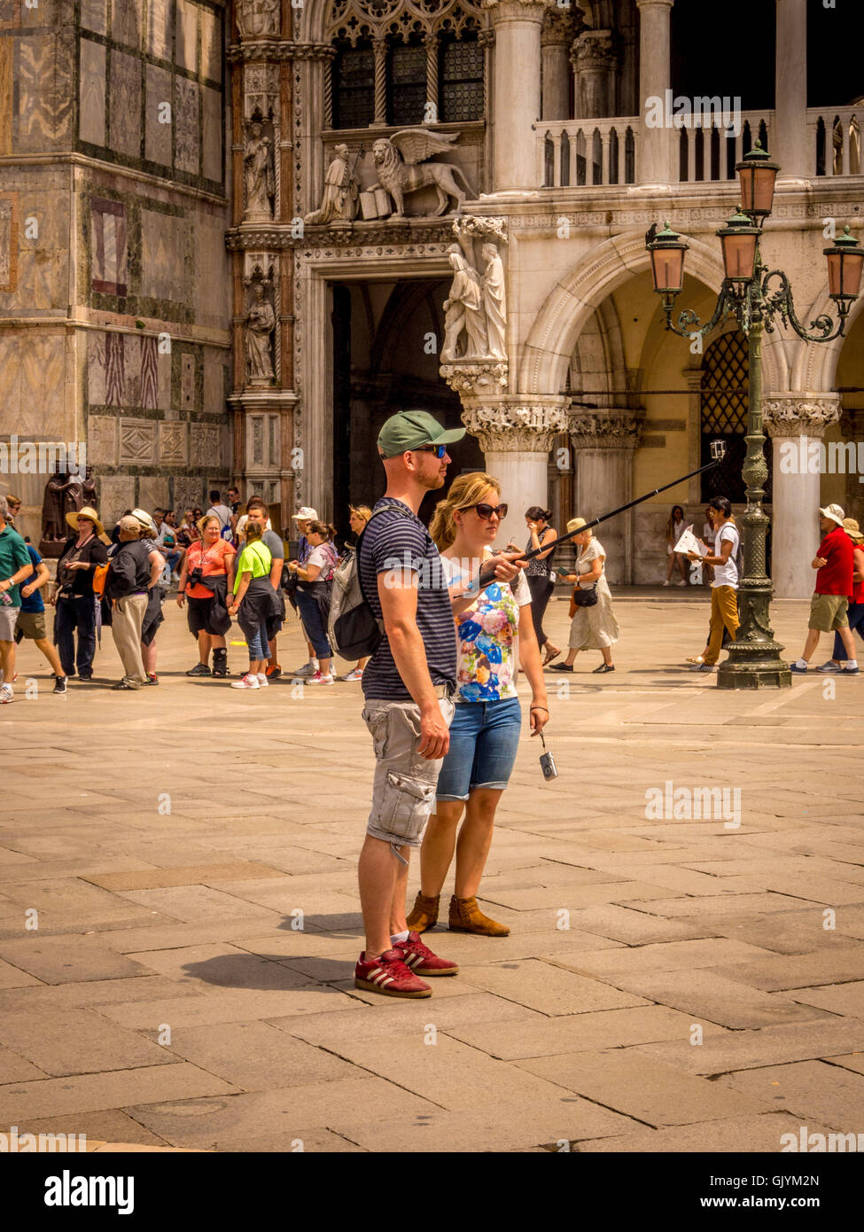 Männliche Touristen mit Selfie-Stick zu Selfie auf der Piazetta San Marco in Venedig, Italien. Stockfoto