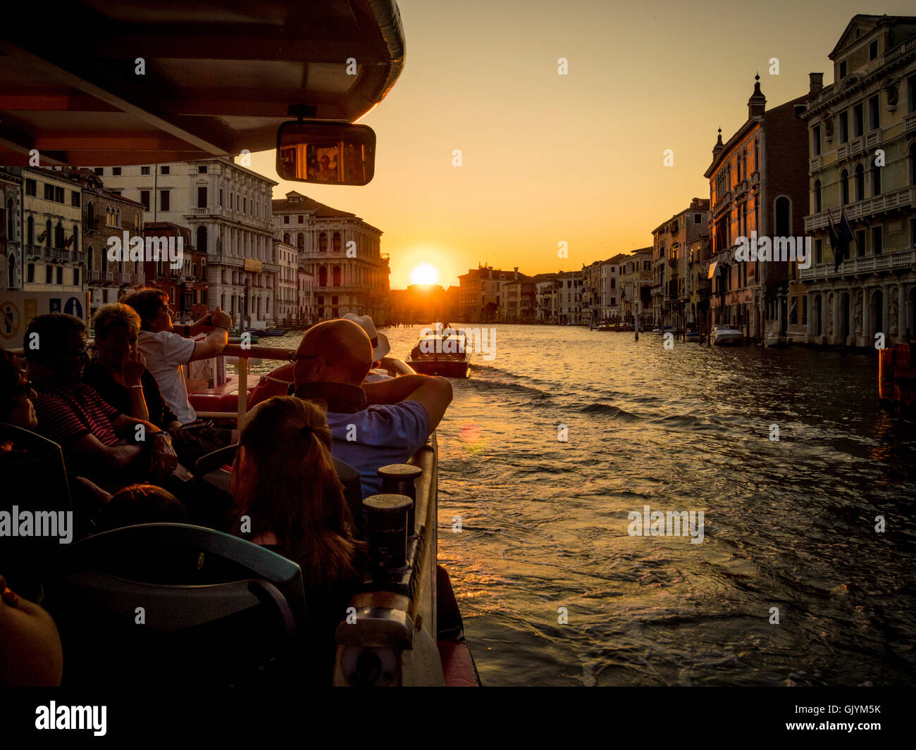 Passagiere auf dem Wasserbus oder Vaporetto auf dem Canal Grande bei Sonnenuntergang. in Venedig, Italien. Stockfoto