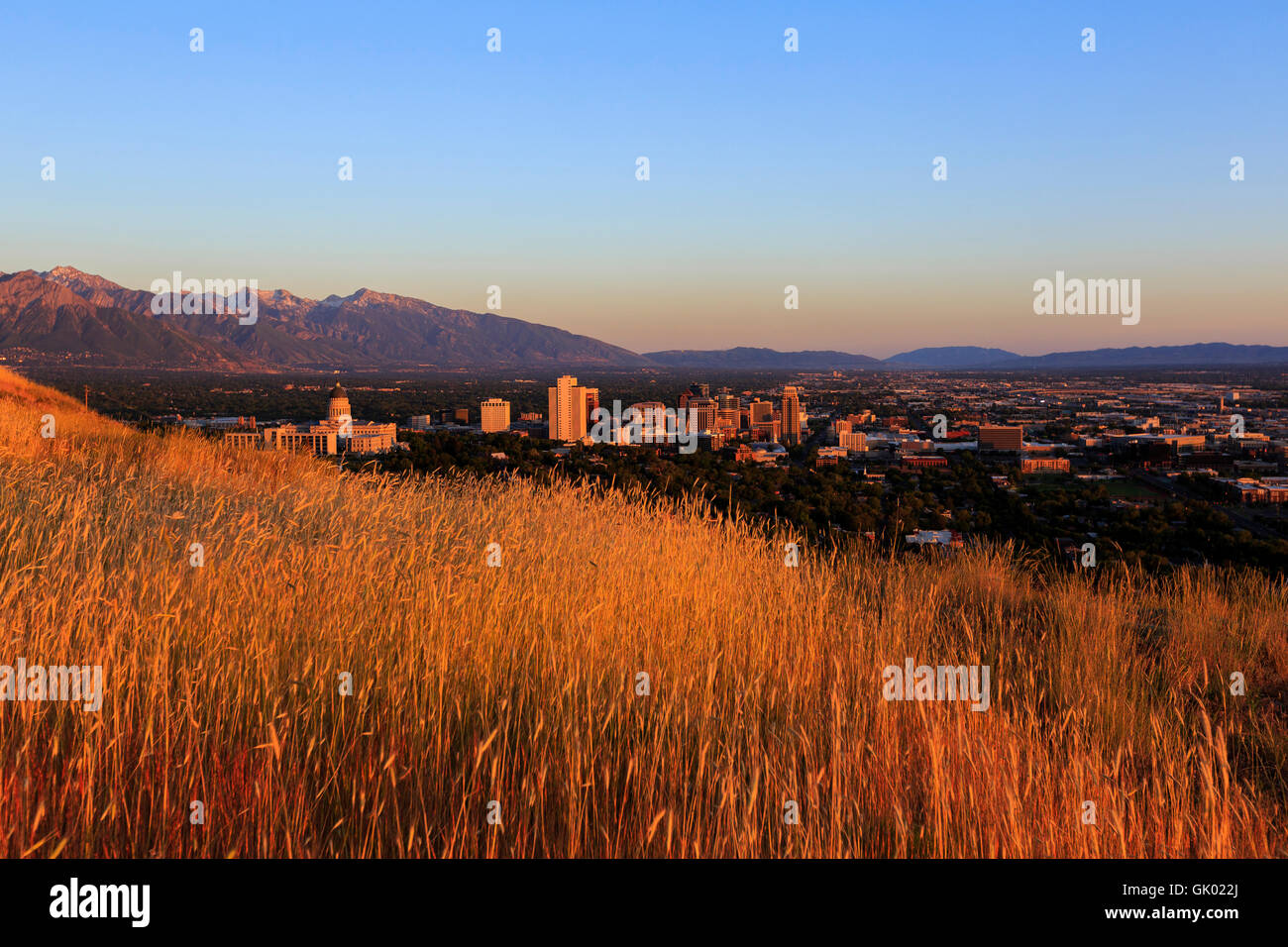 Das warme Licht der untergehenden Sonne leuchtet ein Blick auf die Skyline von Salt Lake City, Utah, USA Stockfoto