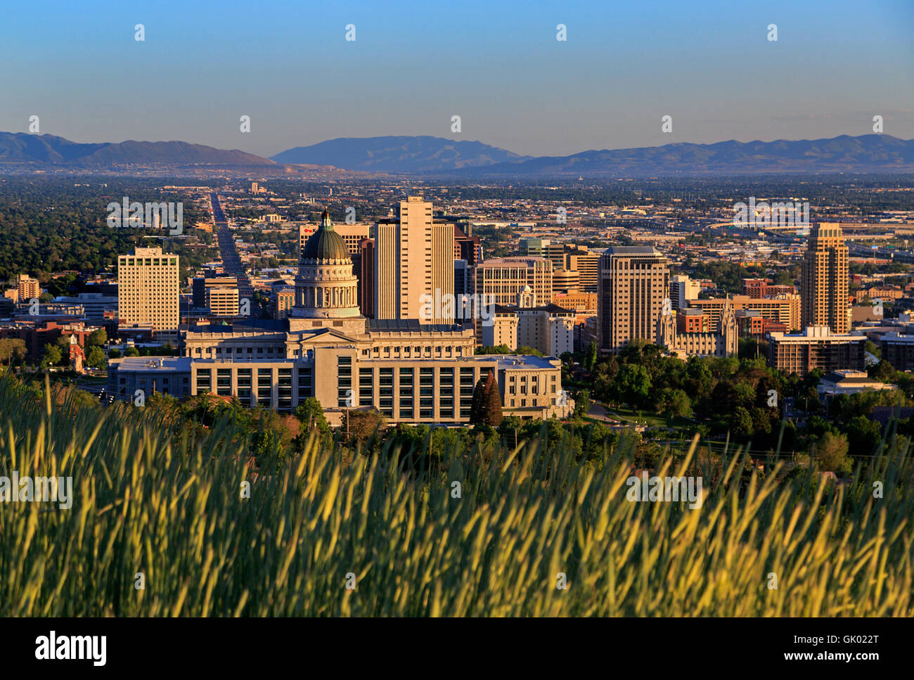 Dabei schoss die Einstellung Sonne leuchtet die Utah State Capitol Building und der Innenstadt von Salt Lake City, Utah, USA Stockfoto
