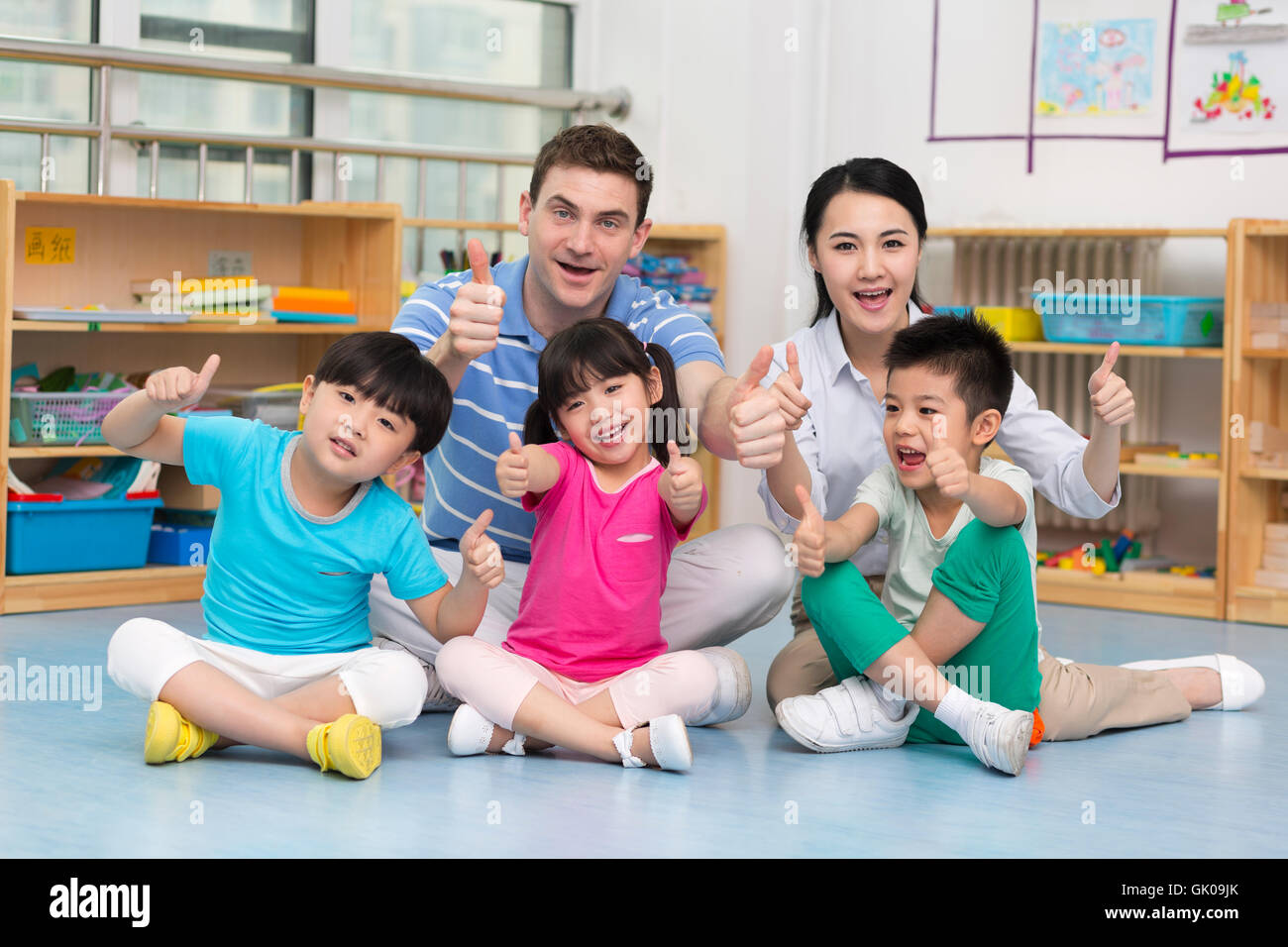 Lehrer und Kinder zusammen spielen Stockfoto