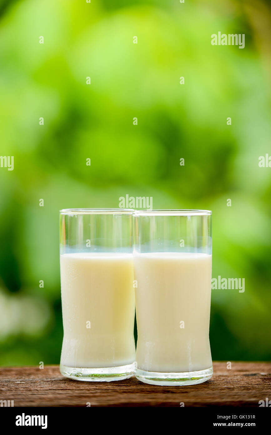 Milchglas auf Tisch mit Natur Hintergrund Stockfoto