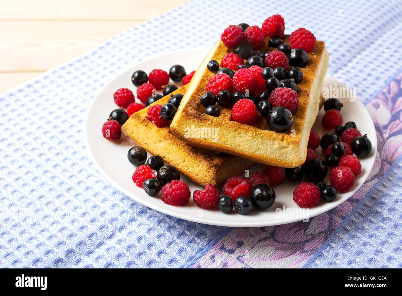 Weiche belgische Waffeln mit Heidelbeeren, Himbeeren und schwarzen Johannisbeeren. Frühstück Waffeln mit frischen Beeren. Stockfoto