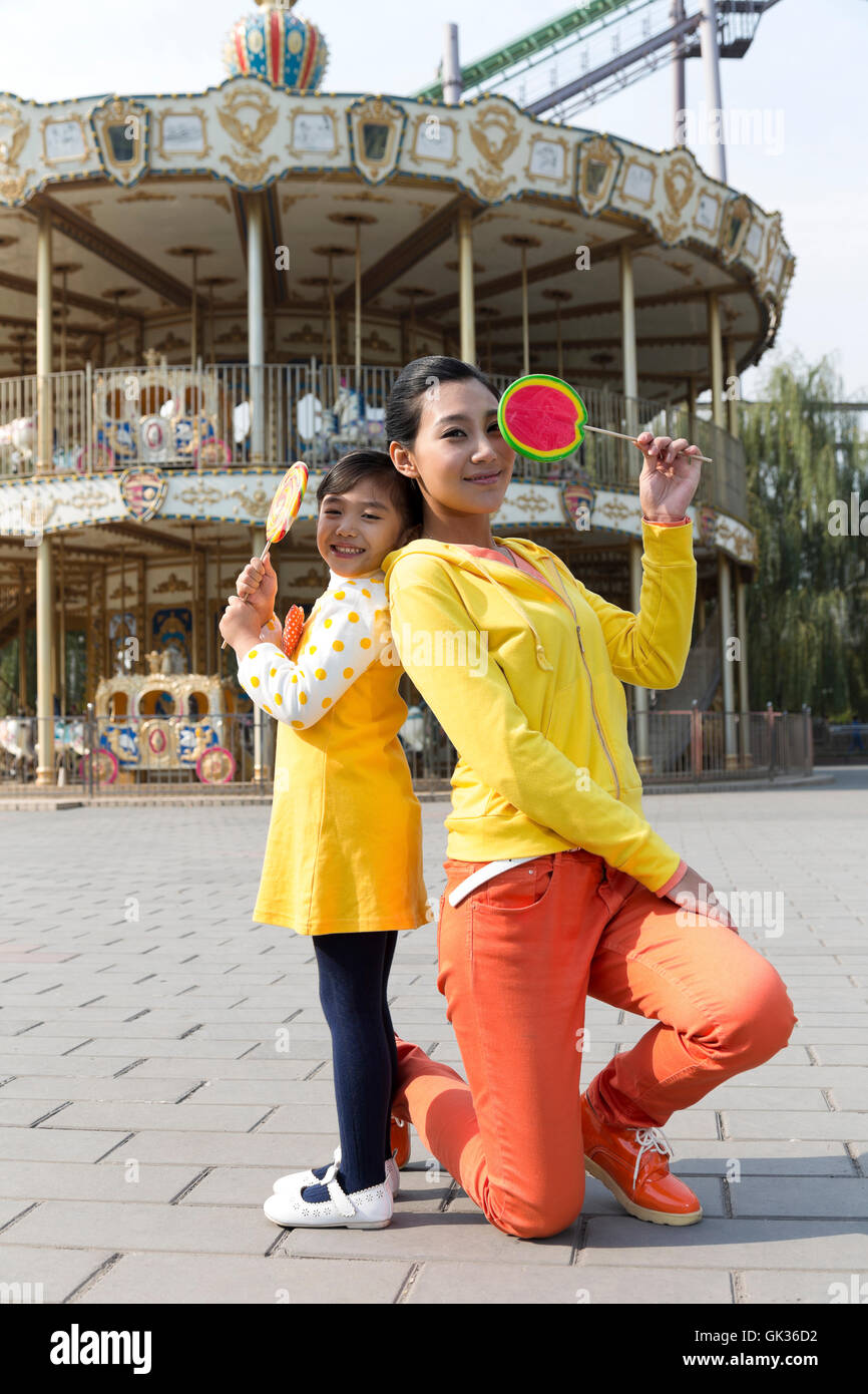 Mutter und Tochter hält einen Lutscher in den Vergnügungspark Stockfoto