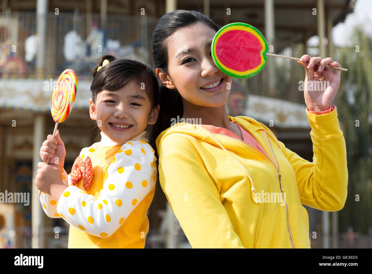 Mutter und Tochter hält einen Lutscher in den Vergnügungspark Stockfoto