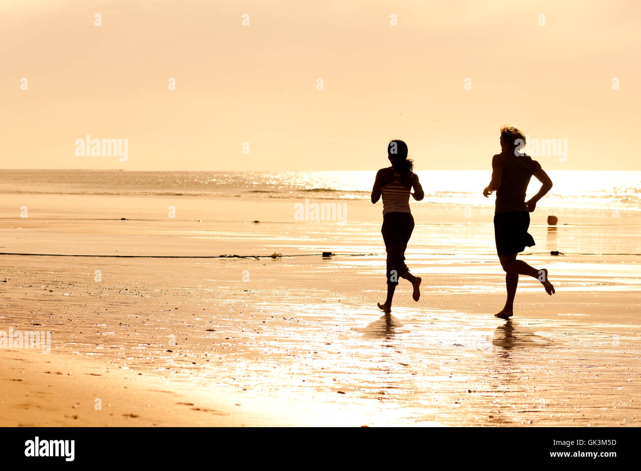 Sport-paar jogging am Strand Stockfoto