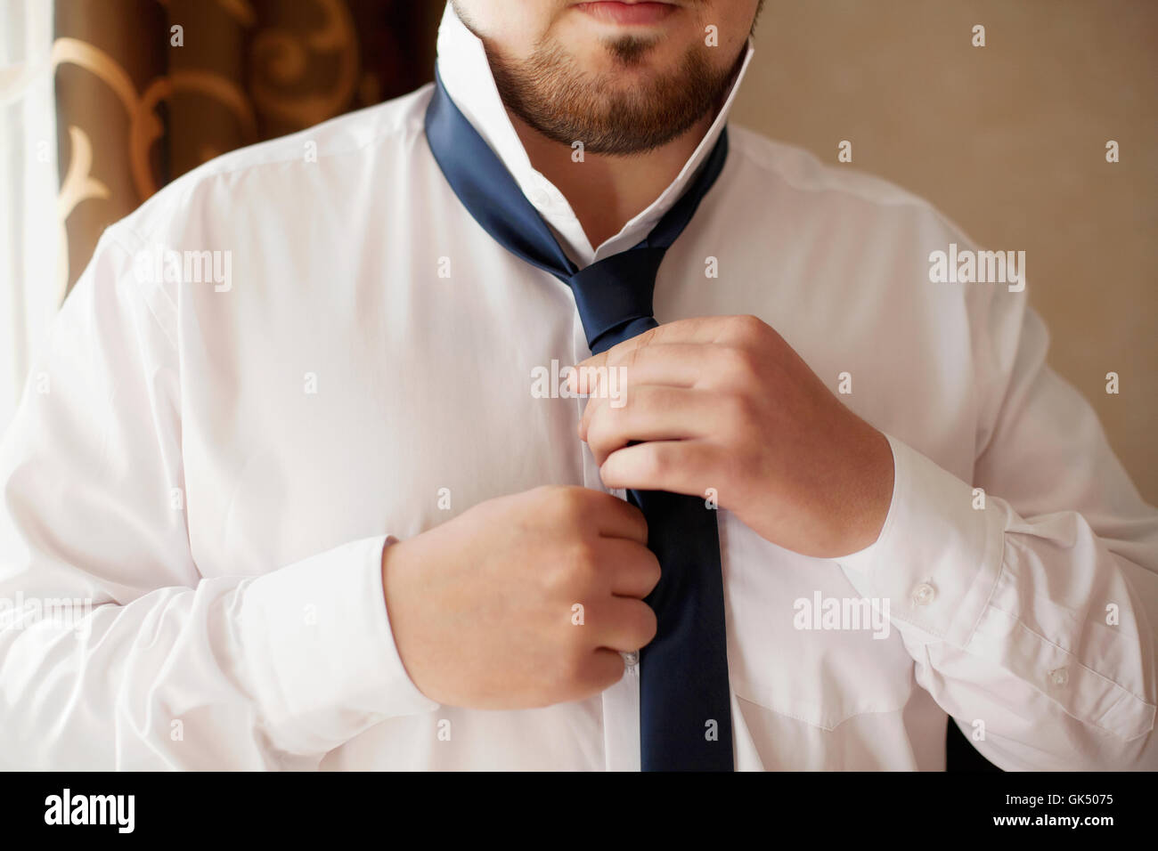 Mann in weißen Hemd Befestigung seine schwarze Krawatte, Nahaufnahme Stockfoto