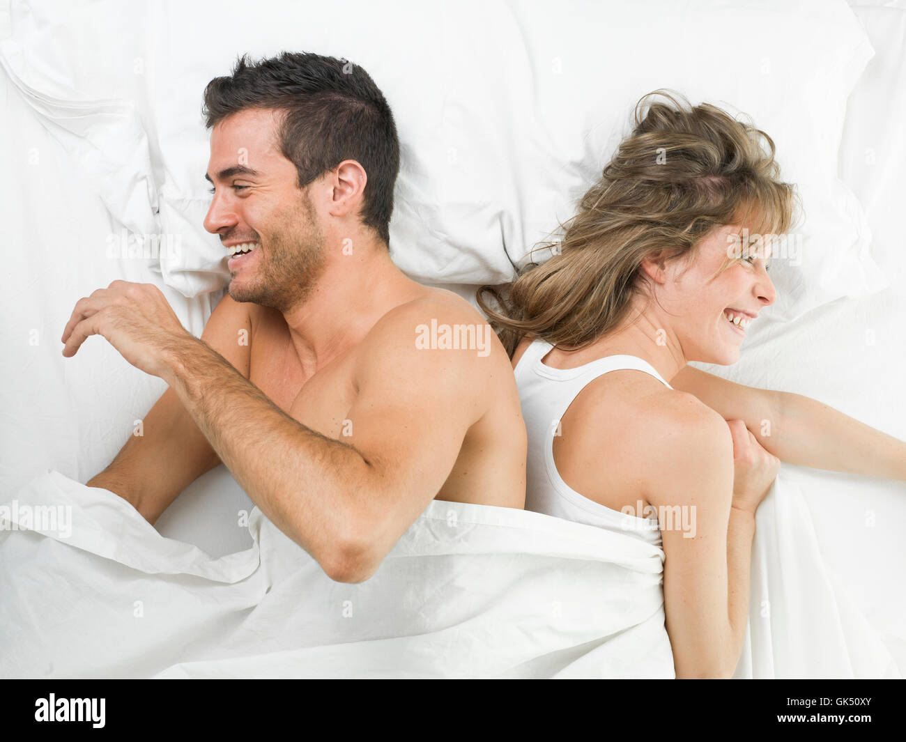 attraktives Paar in Liebe Lachen auf Bett Stockfoto