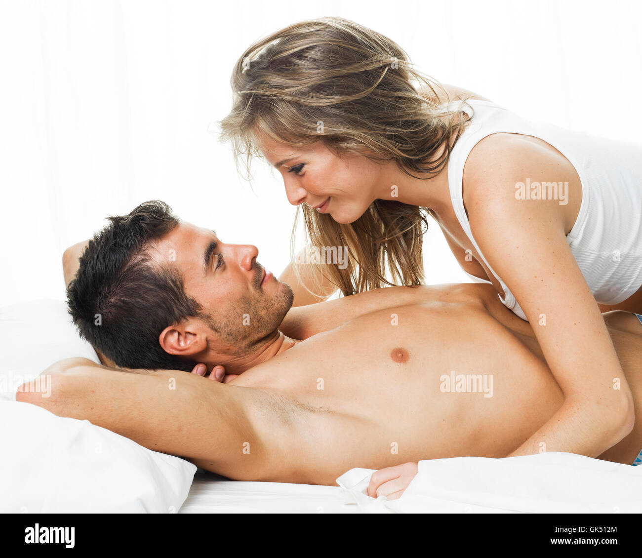 attraktives Paar in Liebe unter weißen Bettwäsche Stockfoto
