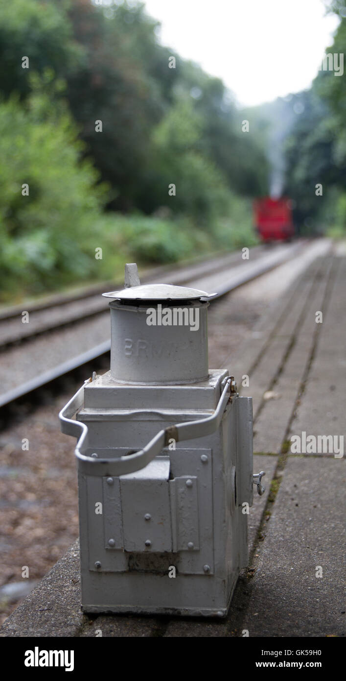 abstraktes Bild mit Fokus auf eine Eisenbahn Lampe die Dampflokomotive Rücken hinunter zum Zug. Stockfoto
