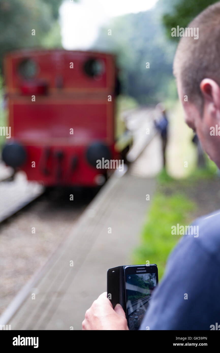 Ein Passagier fängt den Moment mit seiner Kamera-Handy, wie die Dampfmaschine zurück in den Zug Richtung bewegt. Stockfoto