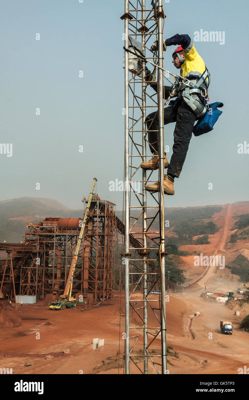 Eisenerz Bergwerk in Sierra Leone auf dem Weg zu Process plant. Telekommunikation Ingenieur bis Tower arbeiten an Mikrowelle Radio Network Link, Einstellung der Antennenausrichtung. Stockfoto