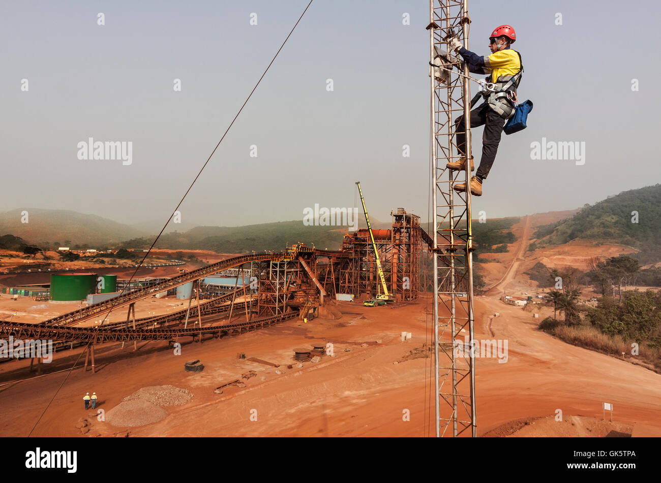 Eisenerz Bergwerk in Sierra Leone auf dem Weg zu Process plant. Telekommunikation Ingenieur bis Tower arbeiten an Mikrowelle Radio Network Link, Einstellung der Antennenausrichtung. Stockfoto