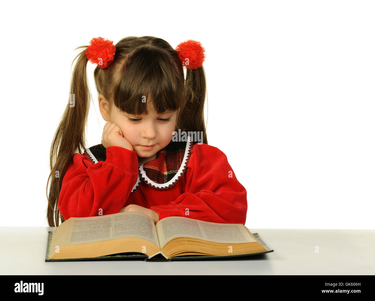 Das kleine Mädchen vor dem großen wissenschaftlichen Buch Stockfoto