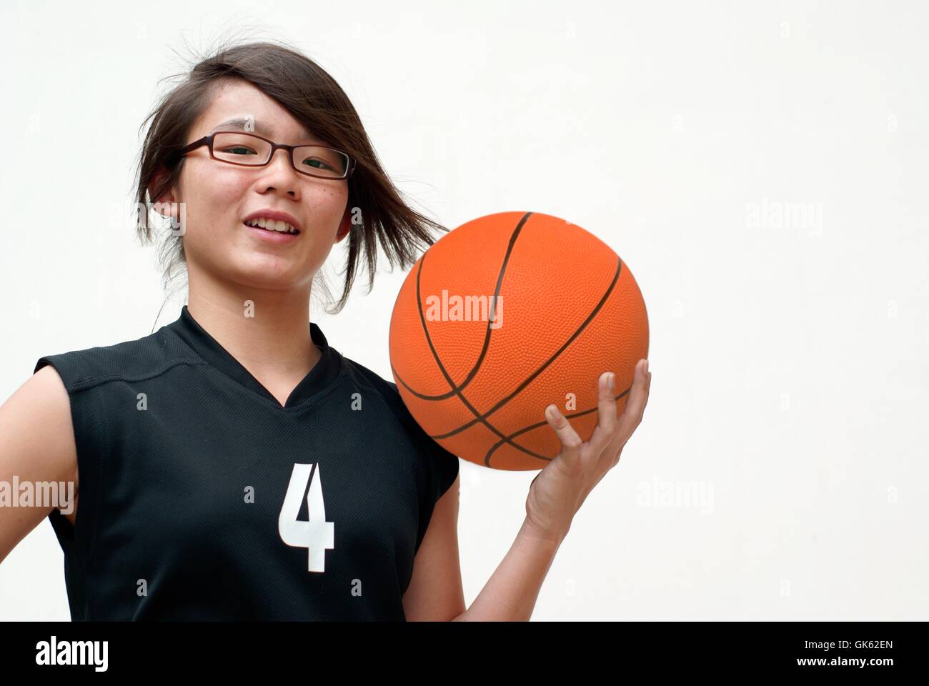Asiatische Teen weiblichen Basketball hält lächelnd Stockfoto