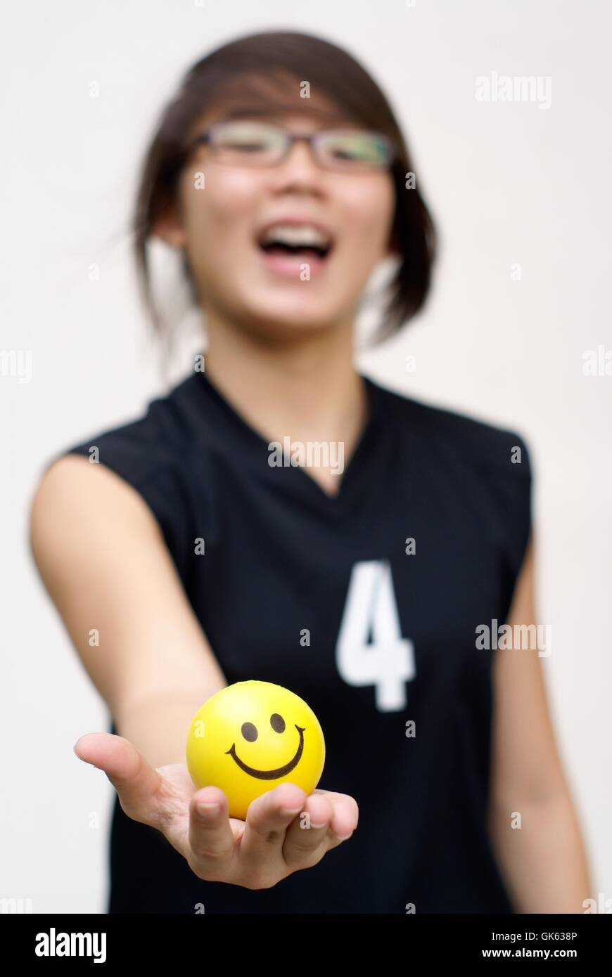 Asiatische Frau mit gelben glücklich Ball in der hand Stockfoto
