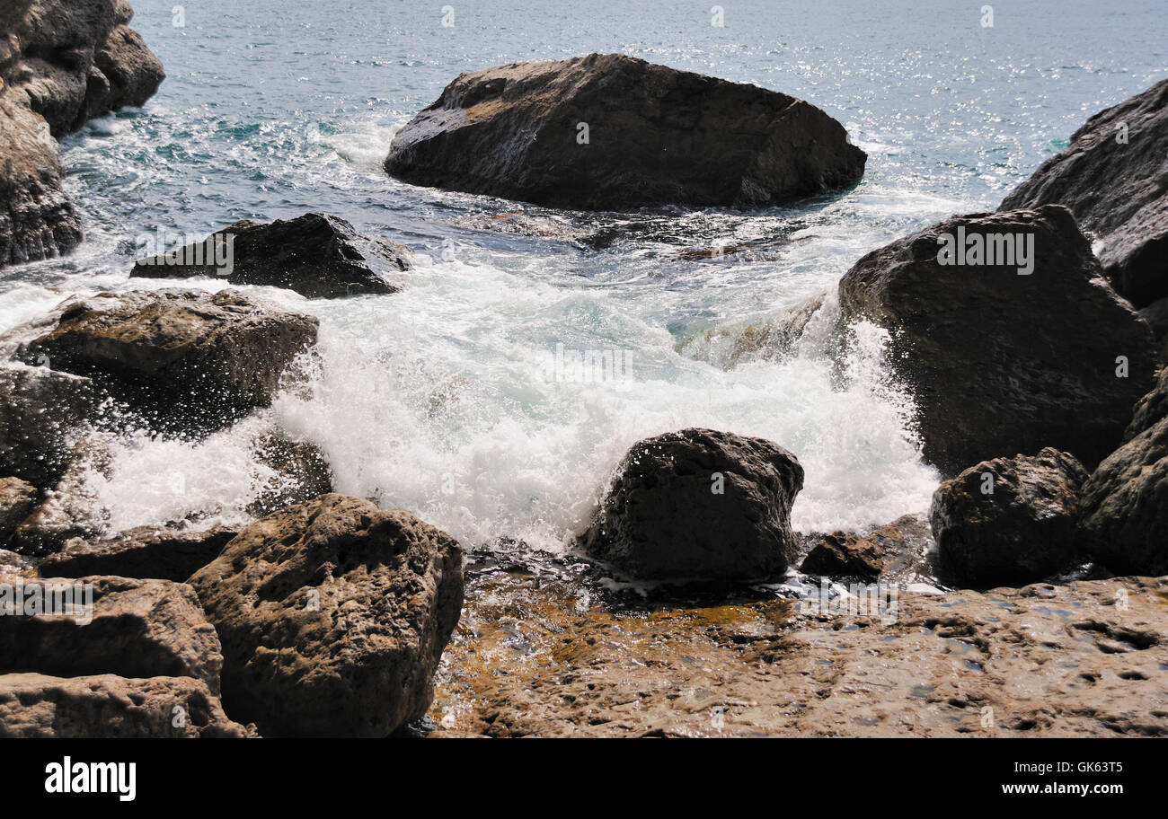 Spritzen der Wellen über Küsten Stones Stockfoto