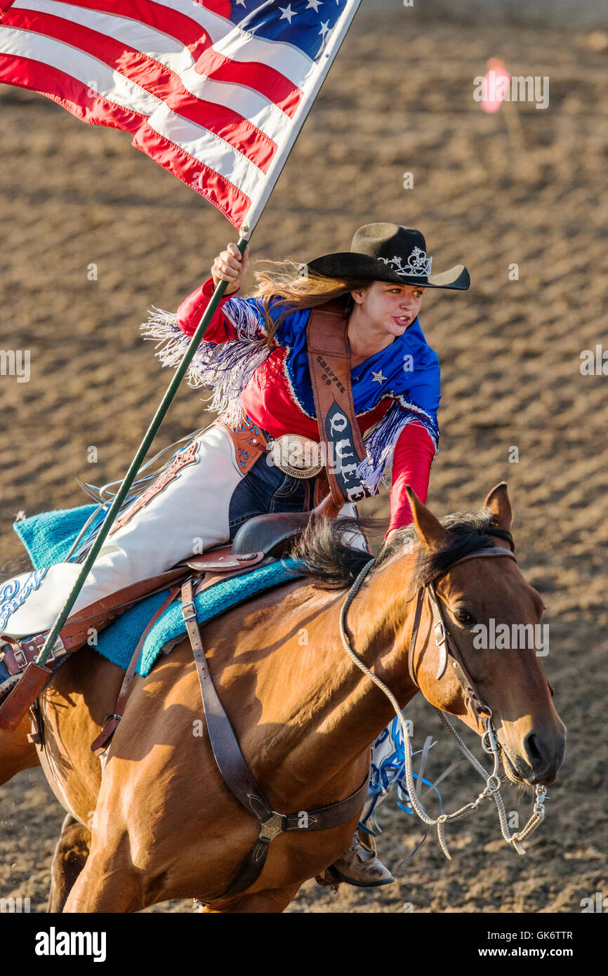 Rodeo Queen auf dem Pferderücken mit amerikanischen Flagge; Chaffee County Fair & Rodeo, Salida, Colorado, USA Stockfoto