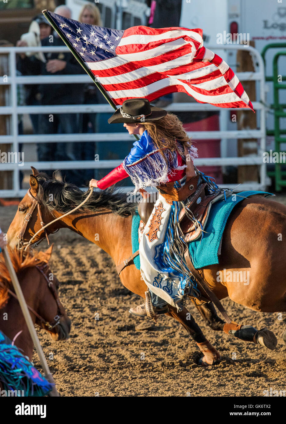 Rodeo Queen auf dem Pferderücken mit amerikanischen Flagge; Chaffee County Fair & Rodeo, Salida, Colorado, USA Stockfoto