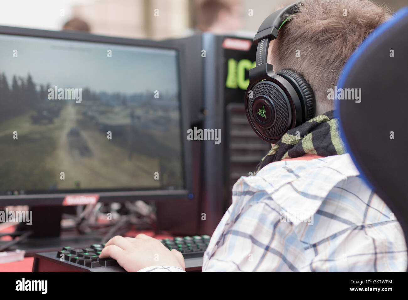 BRNO, Tschechische Republik - 30. April 2016: Junger Mann sitzt auf Gaming-Stuhl und spielt Spiel auf PC bei con, Anime-convention Stockfoto