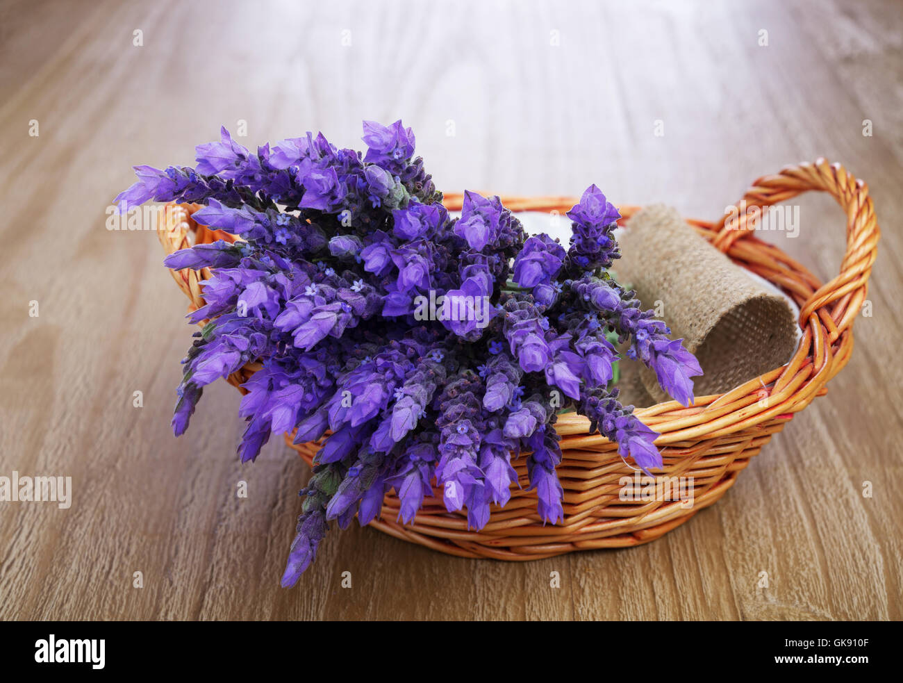 Bündel von Lavendelblüten in Weidenkorb auf Vintage Holztisch Stockfoto