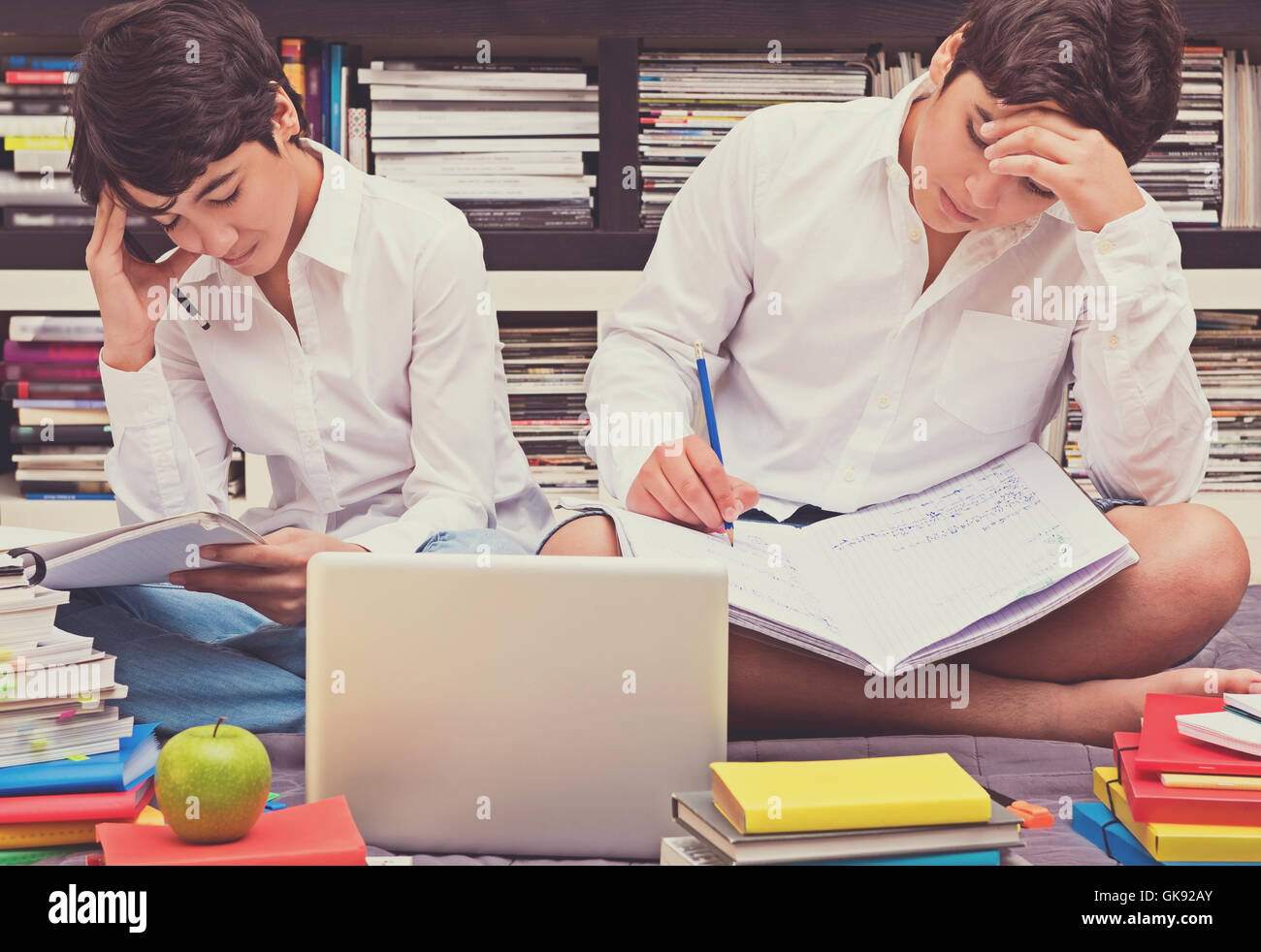 Zwei Schüler sitzen in der Bibliothek und denken über eine schwierige Aufgabe, Heimarbeit, Ausbildung in der High School zu tun Stockfoto