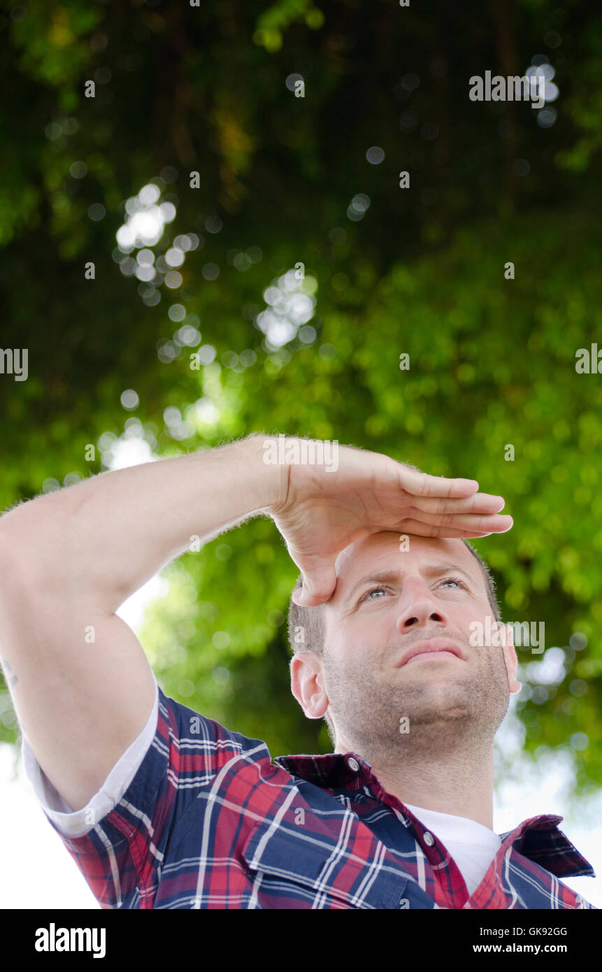 Auf der Suche nach einem besseren Morgen.  Mann sucht mit der Hand über seine Augen. Stockfoto