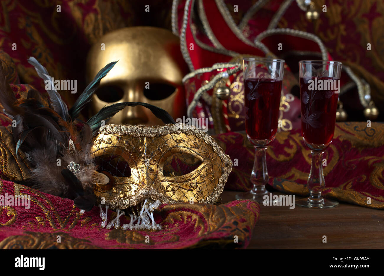 Alte goldene venezianische Masken und Rotwein Stockfoto