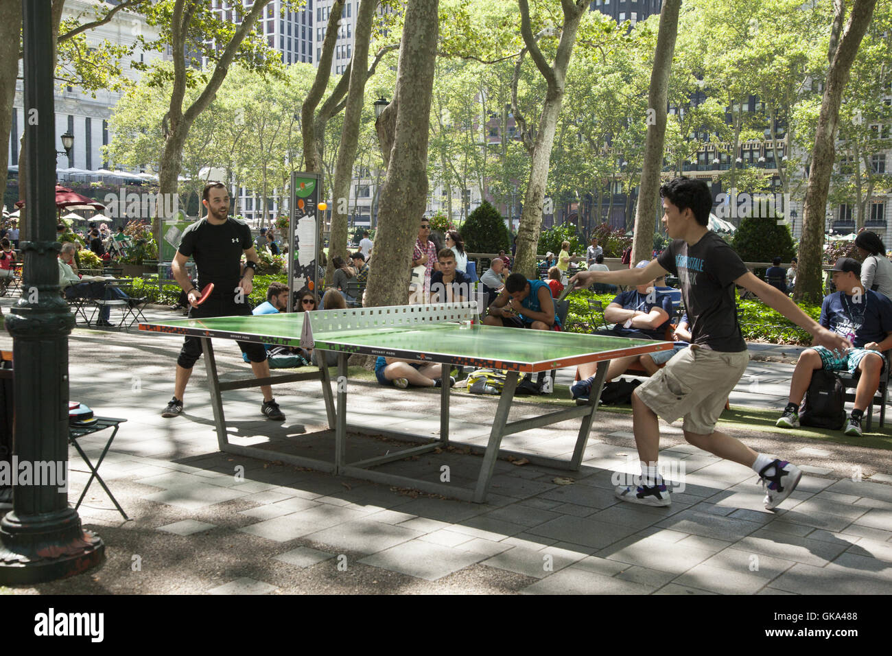 Ein paar ernste Tischtennis-Spieler gehen auf sie auf der free kostenlos Tabellen im Bryant Park entlang der 42nd Street in Midtown Manhattan, NYC. Stockfoto