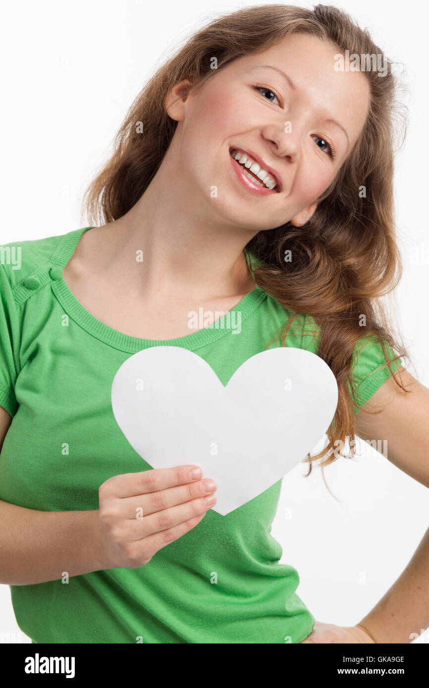 dynamische junge Frau mit einem weißen Herz in der hand Stockfoto