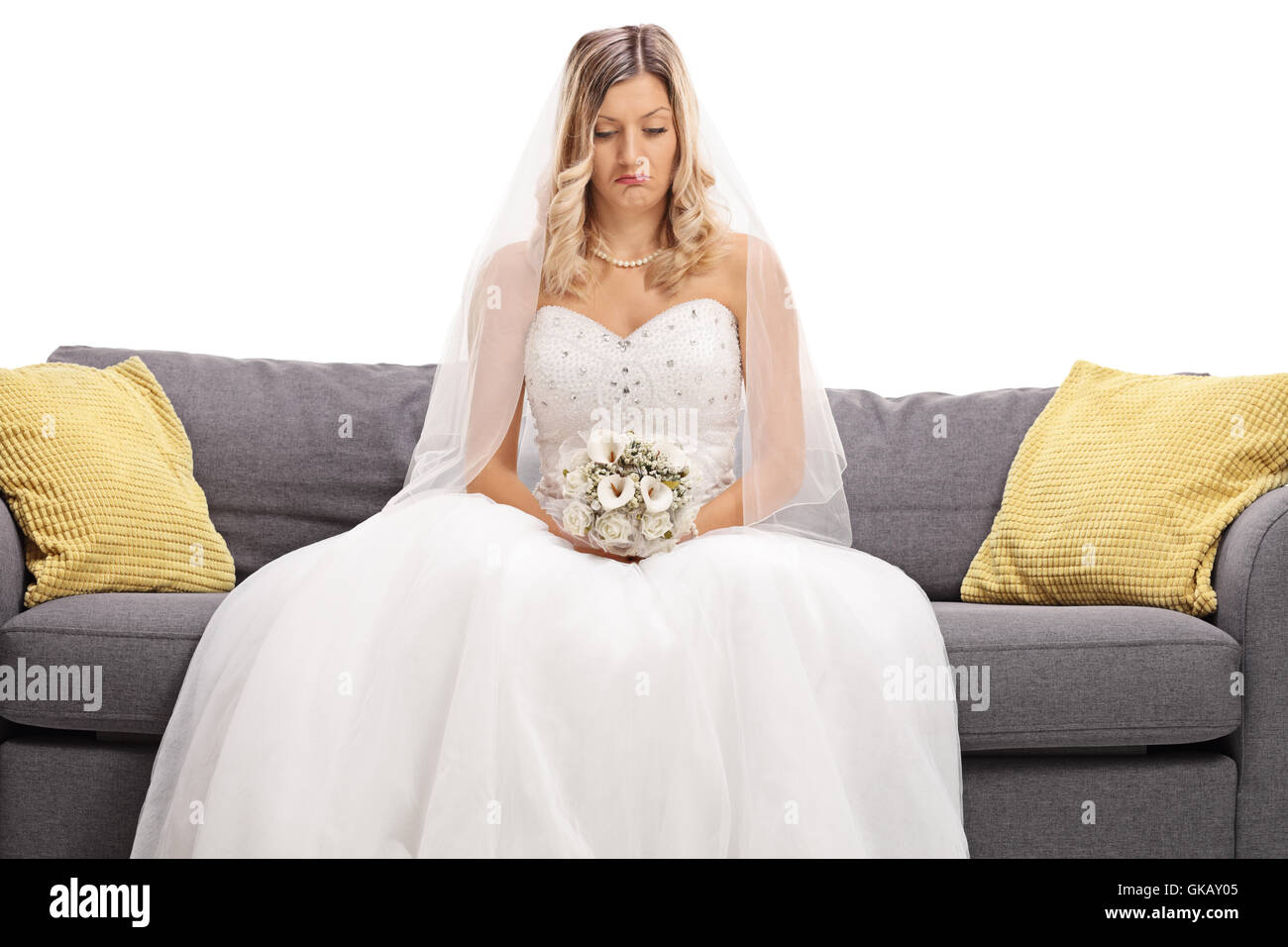 Depressive Braut sitzt auf einem Sofa isoliert auf weißem Hintergrund Stockfoto